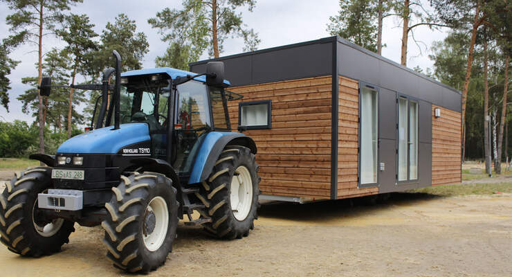 Der Aufbau des Mobile Home Parks auf dem Tropical Islands Gelände ist gestartet. Die ersten Häuser werden mit dem Traktor an ihren endgültigen Platz auf dem Campingplatz gebracht.